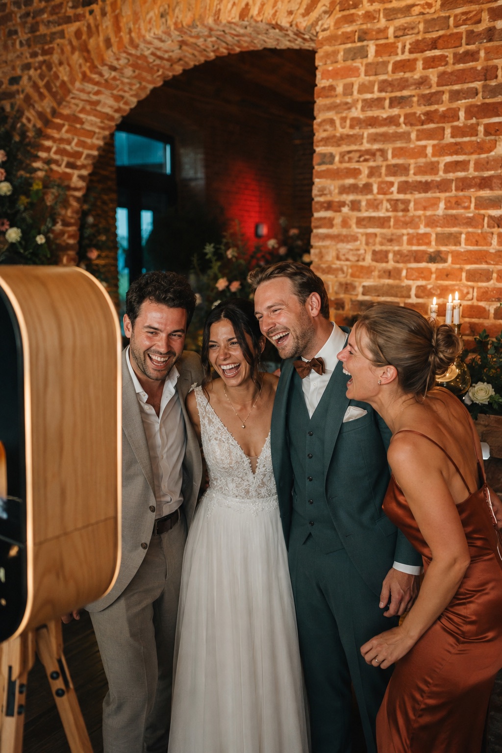 Trouwkoppel en vrienden lachen samen voor een photobooth